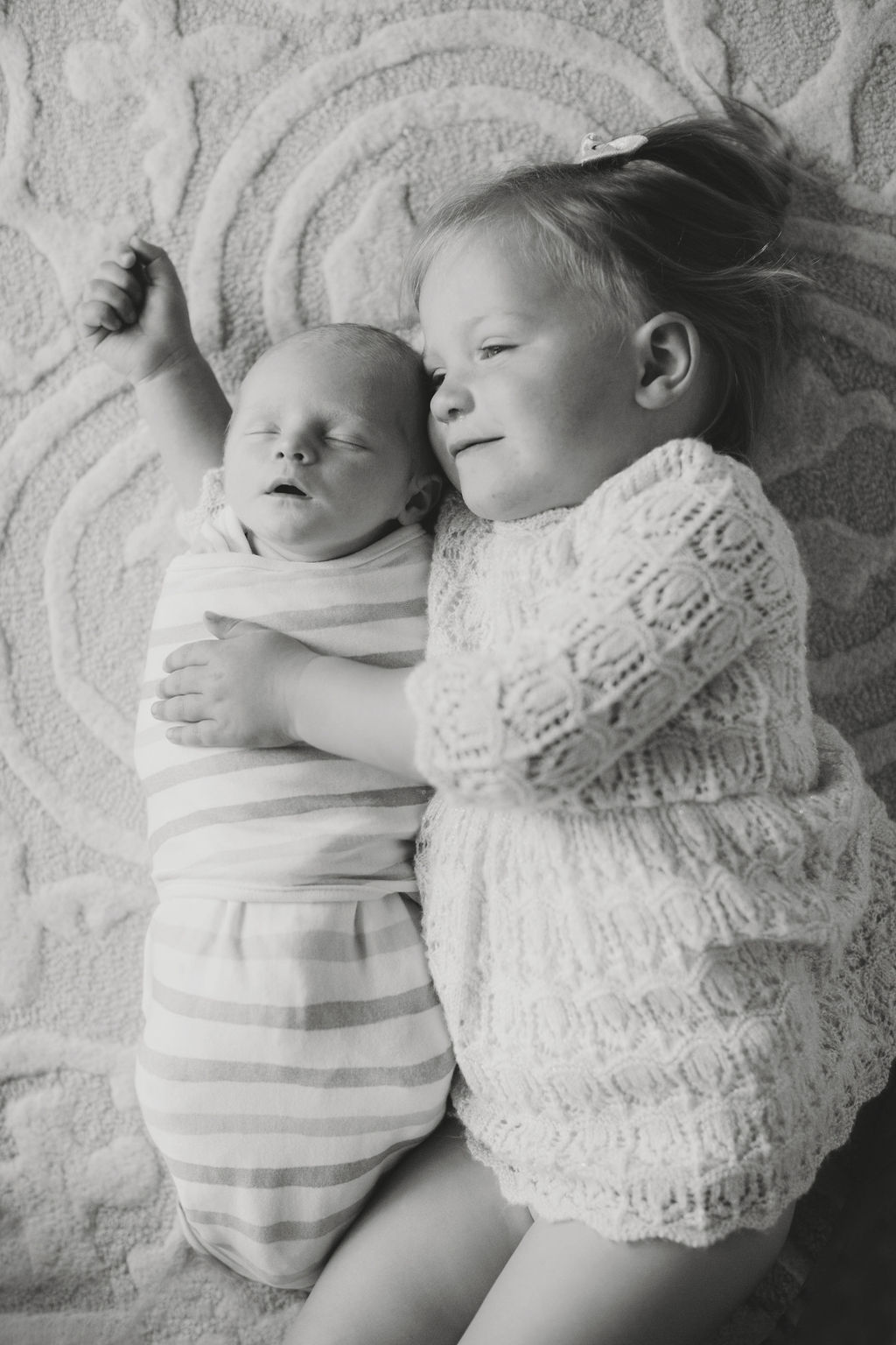newborn with toddler sister black and white portrait