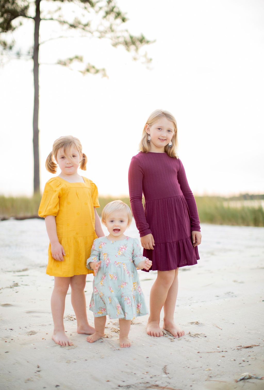 three girls dresses on beach